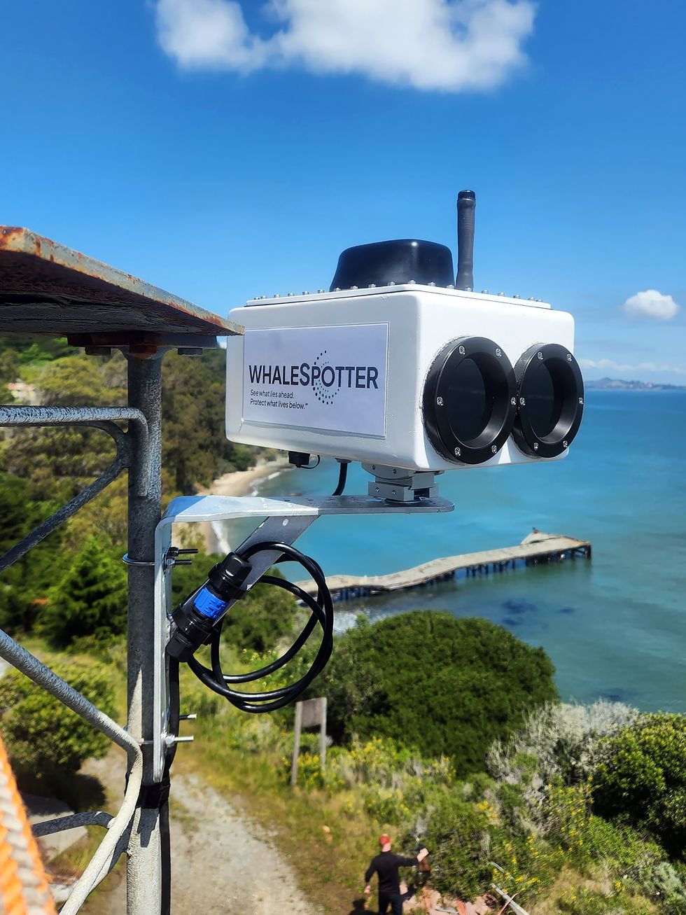A two-lens thermal camera pointed out towards a vibrant bay.
